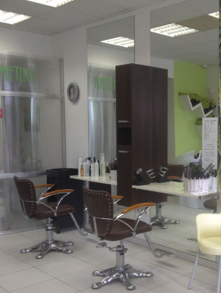Interiér salónu Friseur: kadernícke kreslá pred zrkadlami a limetková stena