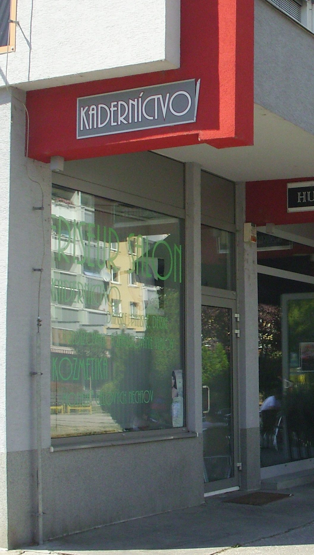 Výklad salónu Friseur pod červeným portálom na pešej zóne Rajeckej ulice vo Vrakuni